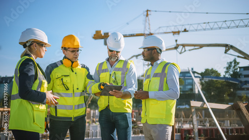 Diverse Team of Specialists Use Tablet Computer on Construction Site. Real Estate Building Project with Civil Engineer, Architect, Business Investor and General Worker Discussing Plan Details. photo