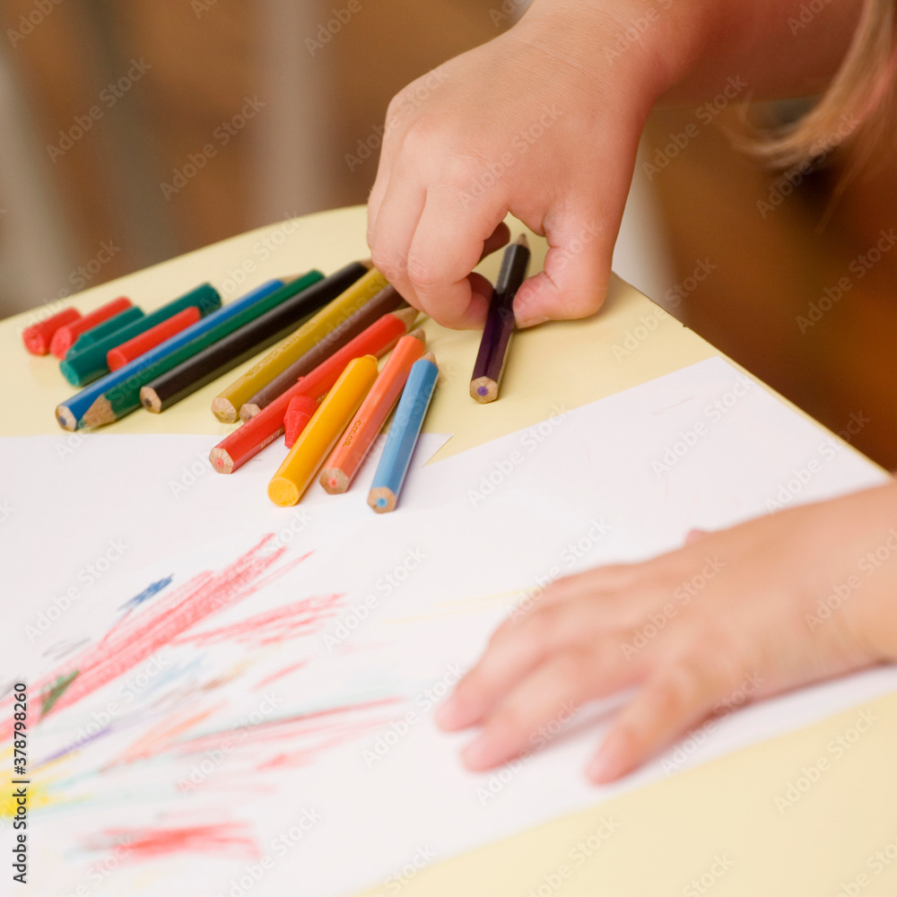 Close-up of a person's hand picking a colored pencil Close-up of a person's hand picking a colored pencil