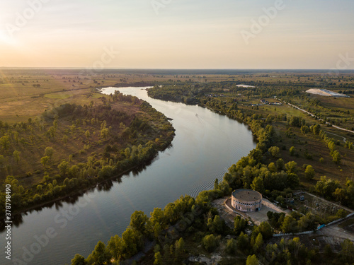 Aerial drone view. The bend of a wide river among green meadows. Sunny summer day. © Sergey