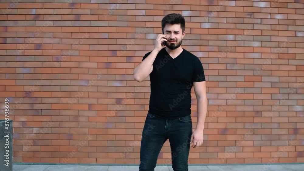 Portrait of a charismatic young man talking on the happy phone. Towards the end of the call, the young man finds good news and is very happy. Portrait of a charismatic young man talking on the happy phone. Towards the end of the call, the young man finds good news and is very happy.
