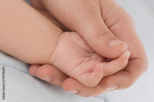 Close-up of a person's hand holding baby's hand