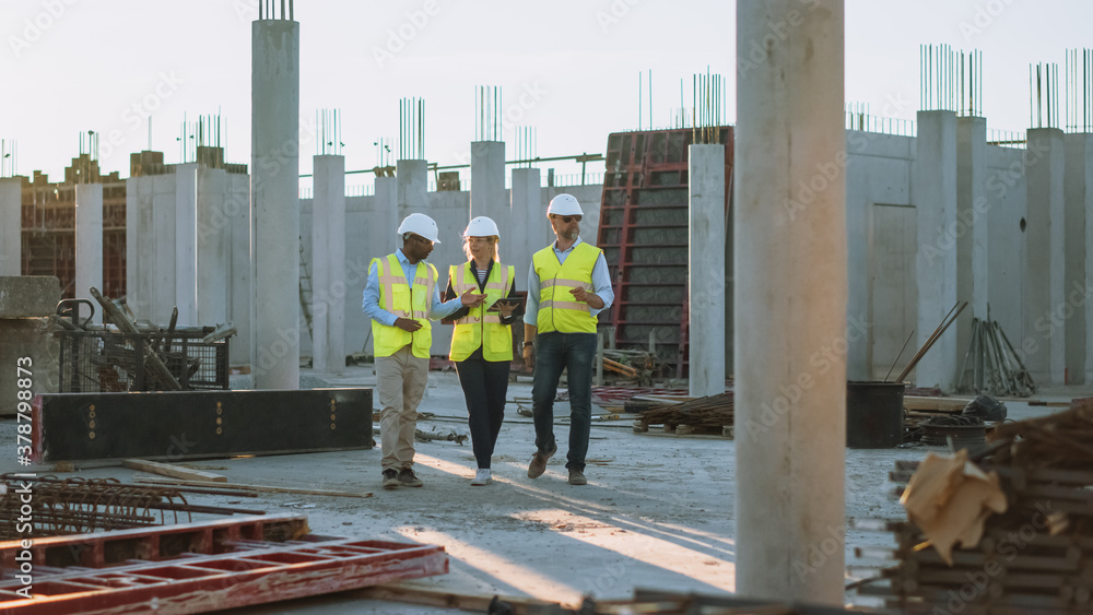 Diverse Team of Specialists Taking a Walk Through Construction Site. Real Estate Building Project with Senior Civil Engineer, Architect, General Worker Discussing Planning and Development Details. Diverse Team of Specialists Taking a Walk Through Construction Site. Real Estate Building Project with Senior Civil Engineer, Architect, General Worker Discussing Planning and Development Details.