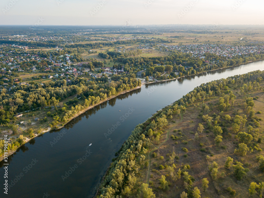 Aerial drone view. The bend of a wide river among green meadows. Sunny summer day.