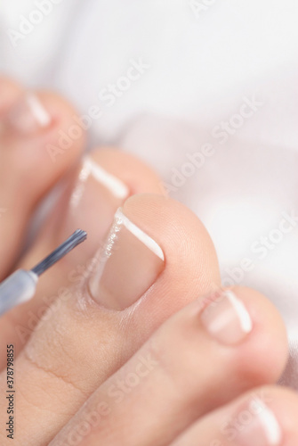 Close-up of a woman applying nail polish on her toes