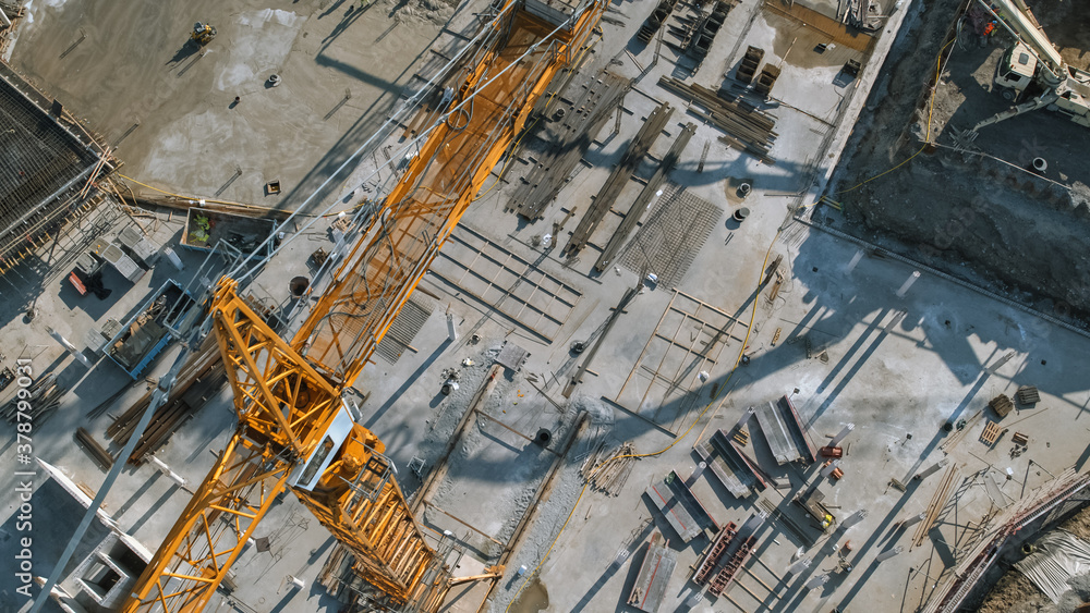 Aerial View of a New Constructions Development Site with High Tower Cranes Building Real Estate. Heavy Machinery and Construction Workers are Employed.
