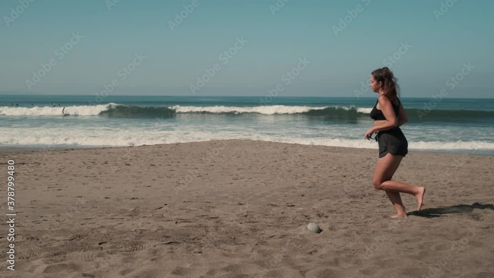 Beautiful woman is jogging along sandy ocean shore Beautiful woman is jogging along sandy ocean shore