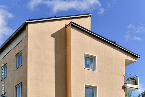 The apartment building in Finland on the blue sky background. Modern nordic architecture.