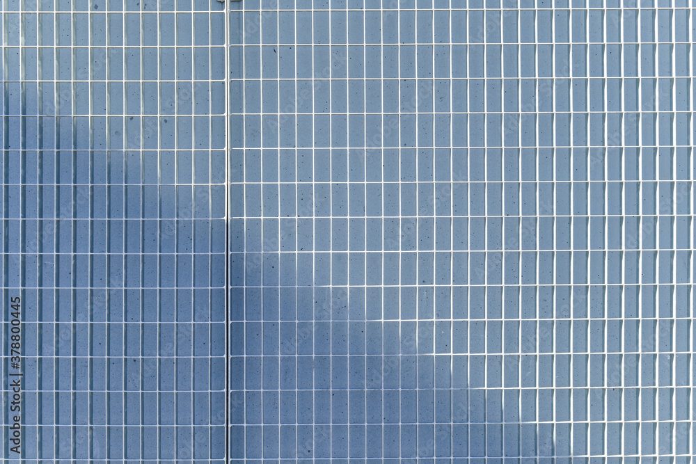 The metal grid on a concrete wall.