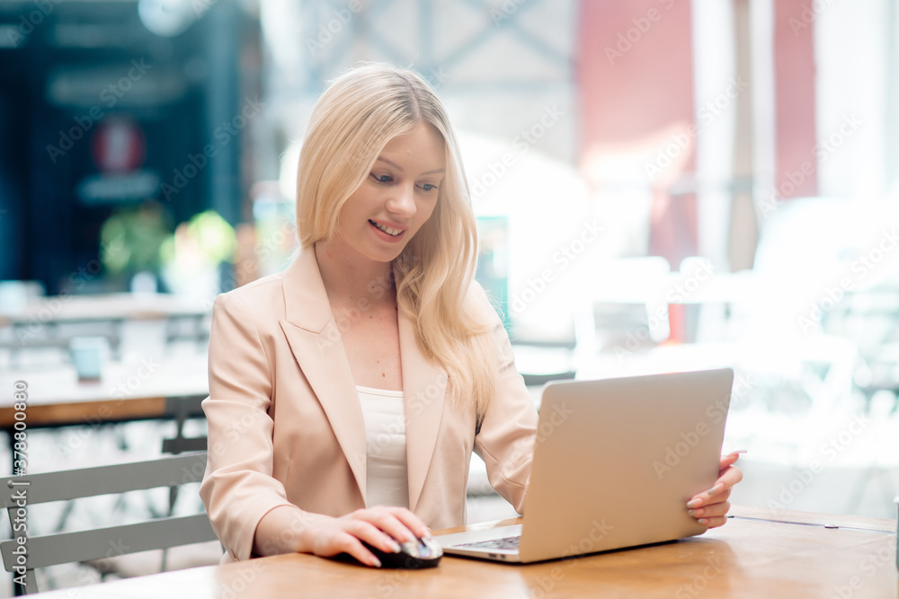 Beautiful business woman sits at a table in a cafe and works remotely at a laptop, negotiating online
Beautiful business woman sits at a table in a cafe and works remotely at a laptop, negotiating online