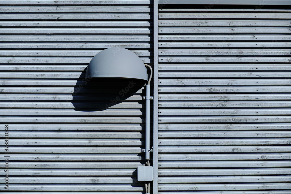The outdoor lamp on the wooden wall.