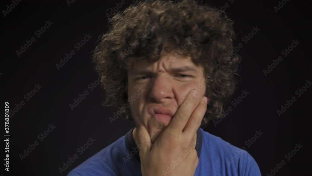 Man looks into the camera with doubt. He's priced in and he's trying to make a choice. Then he looks at the camera in surprise. Isolated background in the studio. High quality 4k footage. Man looks into the camera with doubt. He's priced in and he's trying to make a choice. Then he looks at the camera in surprise. Isolated background in the studio. High quality 4k footage.
