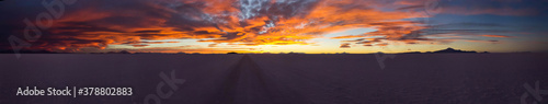 Large natural panorama of salar de Uyuni salt marsh in Bolivia at sunset. Amazing colorful view of setting sun late in evening in good weather. Concept of travel. Copyright space for the site