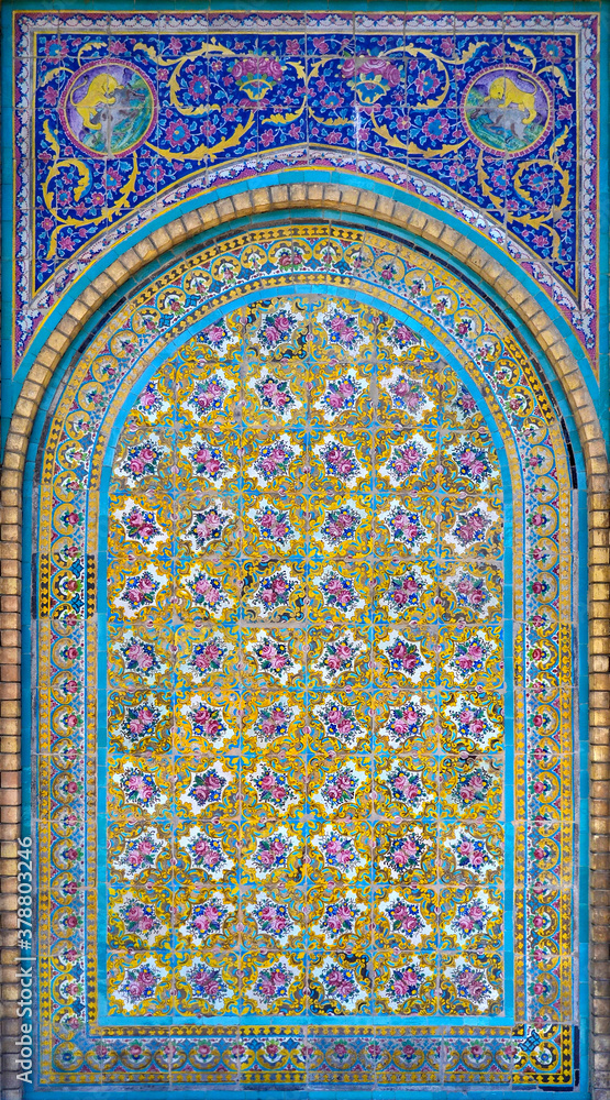 Old, traditional ceramic tiles, pattern of flowers and ornaments, vaulting on the wall in the Golestan Palace complex in Tehran, Iran