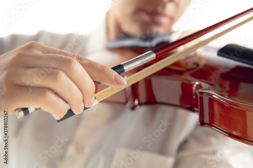 Close up woman playing violin isolated on white studio background. Inspired musician  details of art occupation  world classic instrument. Concept of hobby  creativity  inspiration.