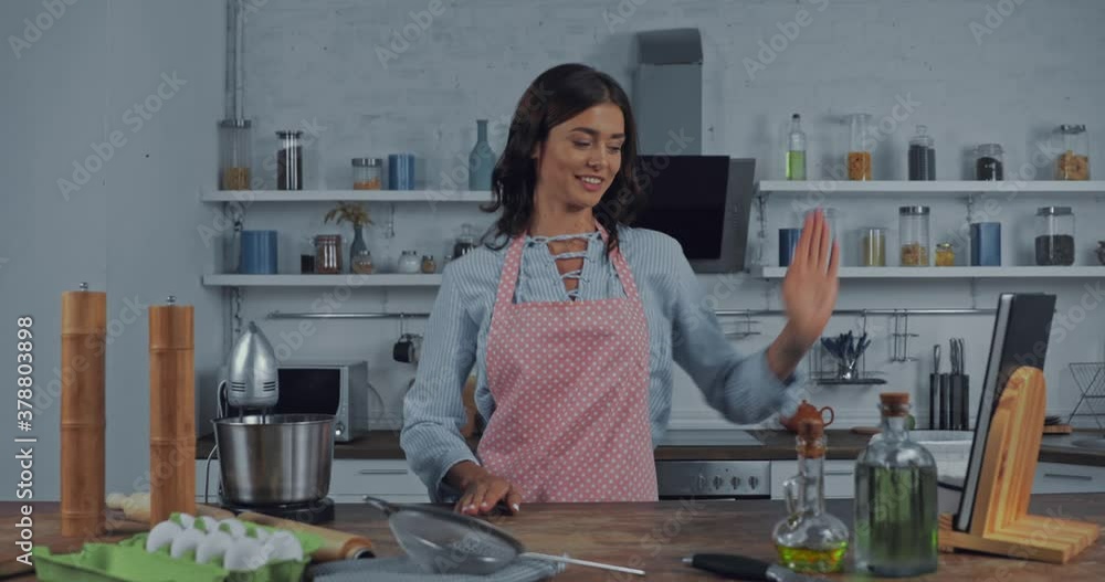 Woman gesturing and talking at camera while cooking in kitchen Woman gesturing and talking at camera while cooking in kitchen