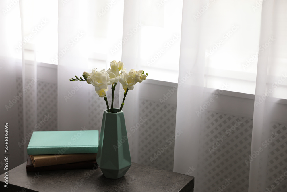 Beautiful spring freesia flowers on table in room