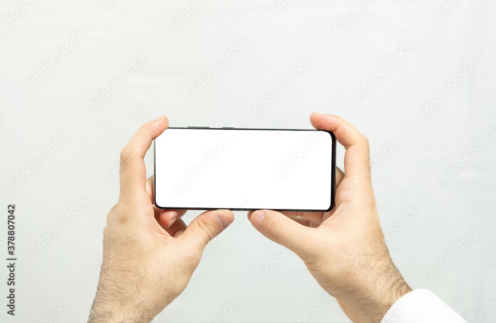 Holding a horizontal white screen smartphone with isolated background Holding a horizontal white screen smartphone with isolated background