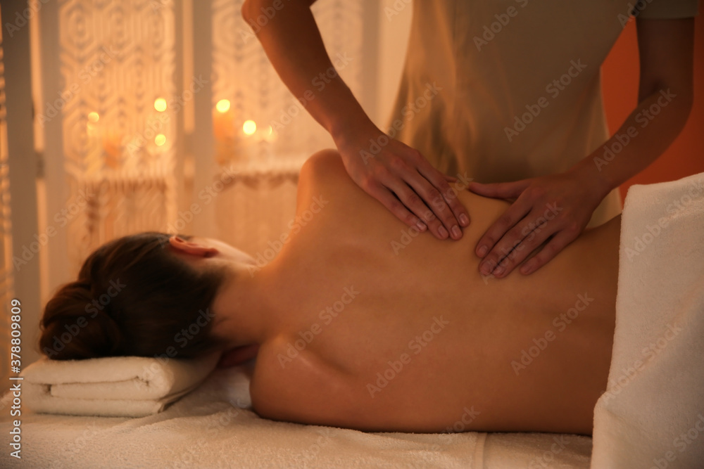 Fototapeta premium Young woman receiving back massage in spa salon