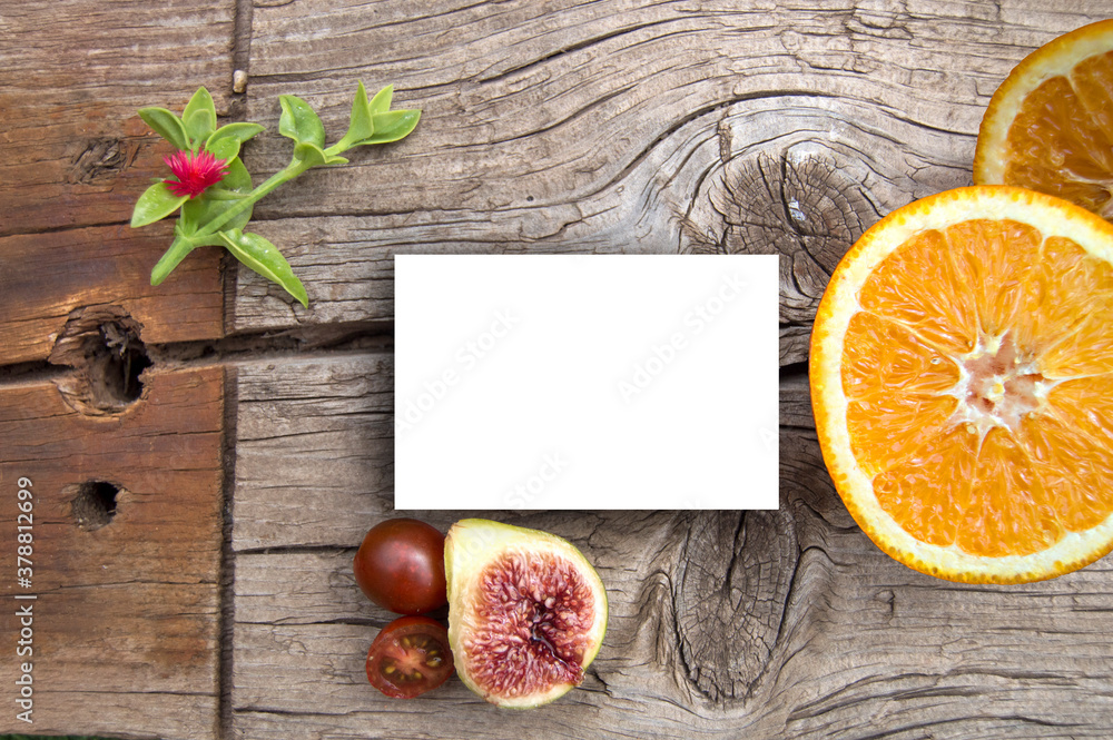 Card on wooden background and fruits presentation