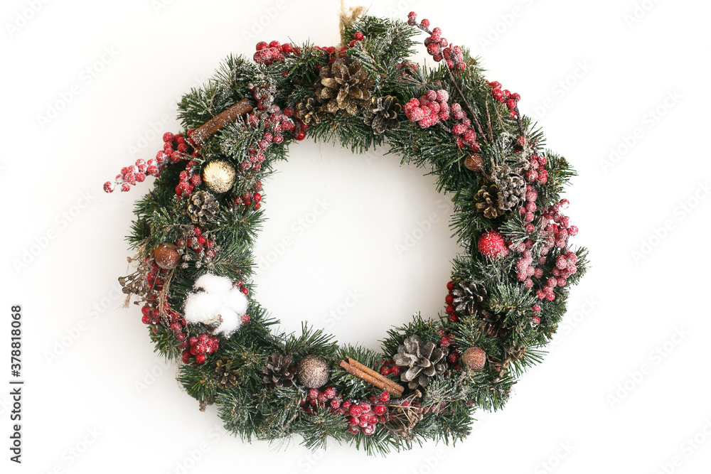 Christmas snowy wreath hanging on white wall in house Christmas snowy wreath hanging on white wall in house