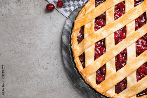Fototapeta Naklejka Na Ścianę i Meble -  Delicious fresh pie and cherries on grey table, flat lay. Space for text