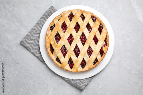 Delicious fresh cherry pie on light grey table, top view