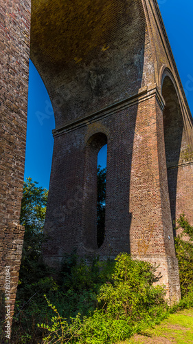 A view looking up towards an arch of the Chappel Viaduct near Colchester  UK in the summertime
