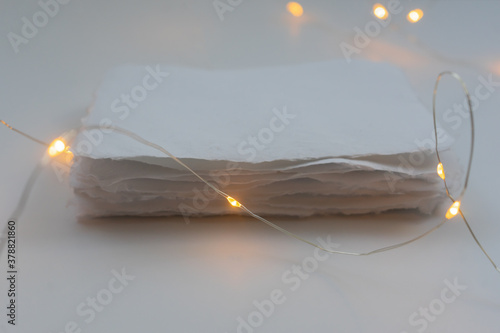 A stack of handmade paper in a festive decoration with lights. The concept of gifts for Christmas and New Year. photo