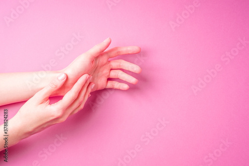 Beautiful female hands showing fresh cute manicure, skin and nail care concept, pink background