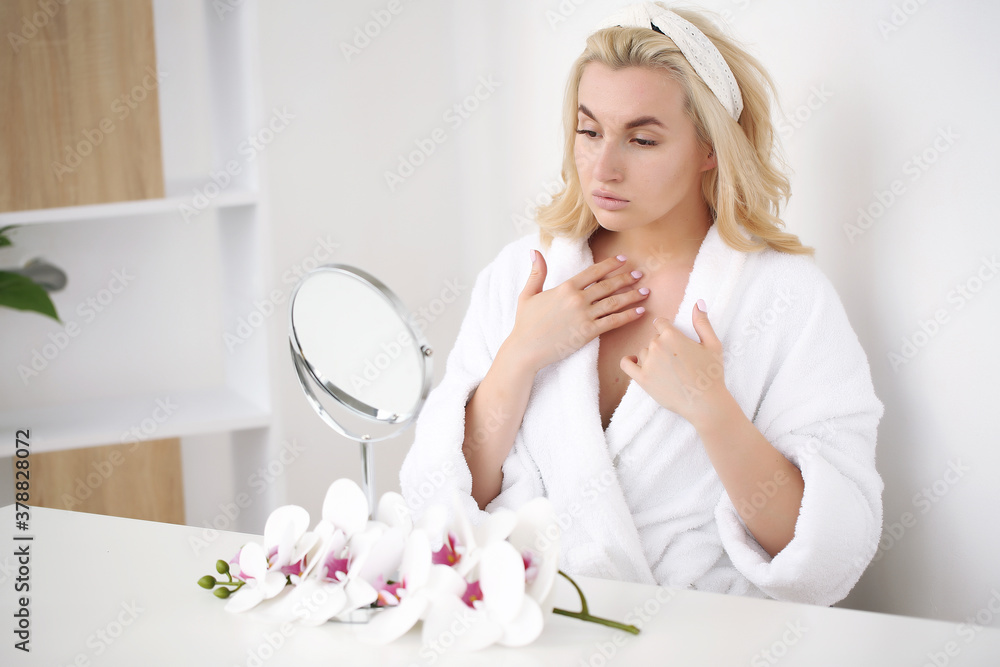 young blonde sitting at the table applying lotion young blonde sitting at the table applying lotion