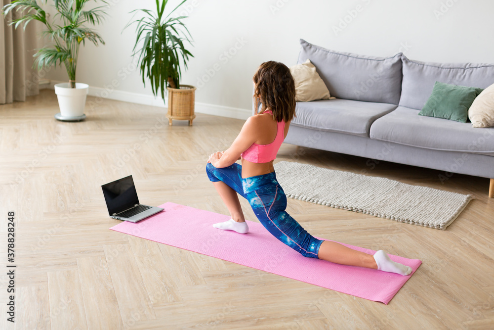 Woman stretcing at home in front of laptop. Woman stretcing at home in front of laptop.