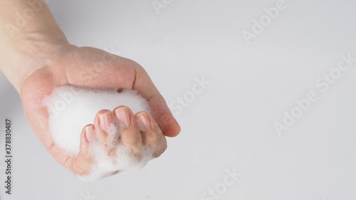Hand washing gesture with foaming hand soap on white background.