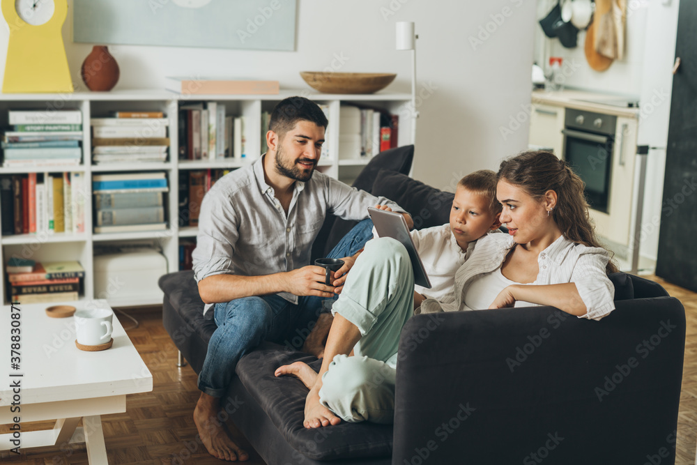 happy family sitting on the sofa and playing using tablet computer at home happy family sitting on the sofa and playing using tablet computer at home