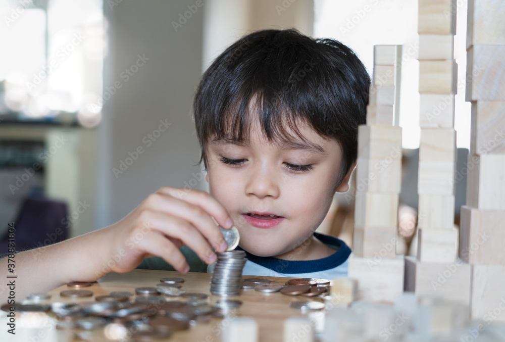 Selective focus happy kid stacking sterling pond coin with blurry ...