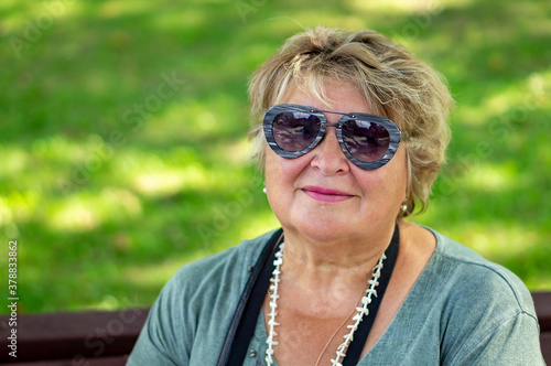 Mature sad woman with glasses resting in a Park