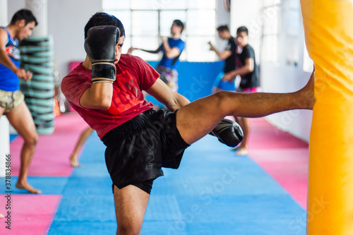 Young Man does kick boxing training in the gym
