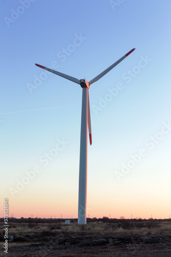 Wind Turbines at Dusk. Landscape sunset with windmills. Renewal source of electricity. Wind turbines field new technology for clean energy on mountain, sunset view with colorful twilight on sky.