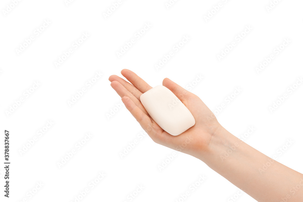 Naklejka premium A bar of soap in female hands on a white background.