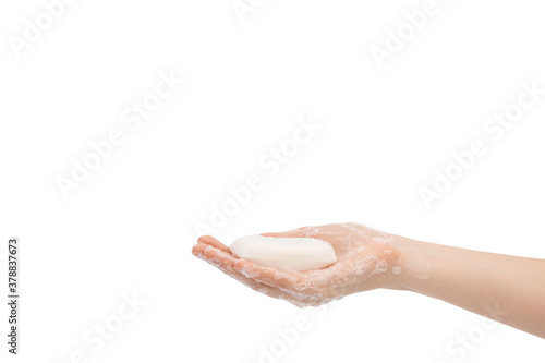 A bar of soap in female hands on a white background.