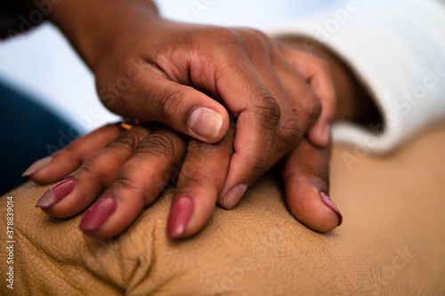close up detail of black hands of grandmother and granddaughter over each other. commitment, aging, care, support, unity concept. .