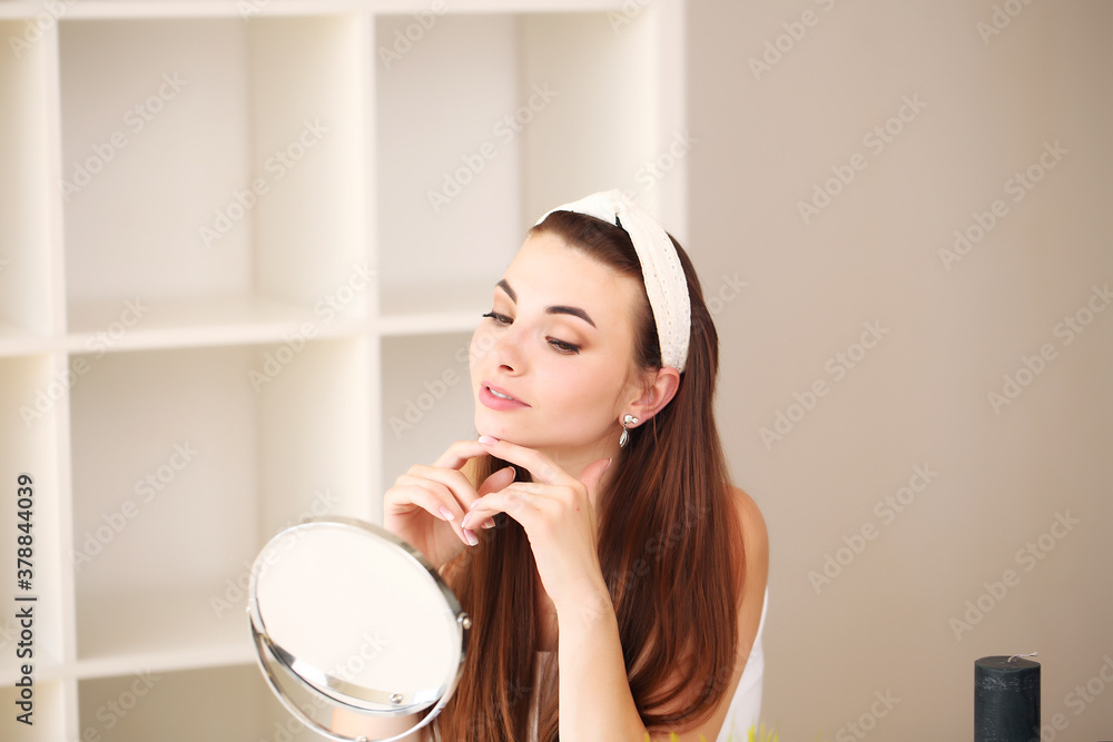 Beauty, skincare and people concept - smiling young girl suggesting beauty for on face in room Beauty, skincare and people concept - smiling young girl suggesting beauty for on face in room
