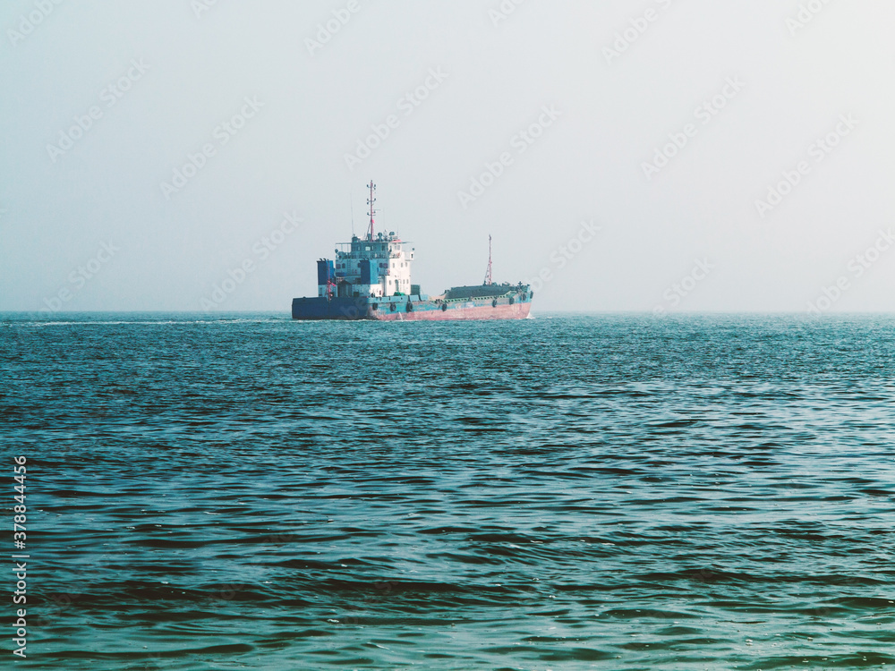 Old cargo ship goes to the industrial and commercial port for cargo loading and further transportation. Shipping, Transportation, Logistic Import Export background Old cargo ship goes to the industrial and commercial port for cargo loading and further transportation. Shipping, Transportation, Logistic Import Export background