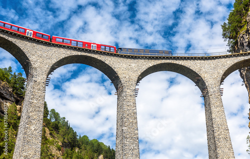Bernina express train runs on Landwasser Viaduct in Alps, Switzerland photo