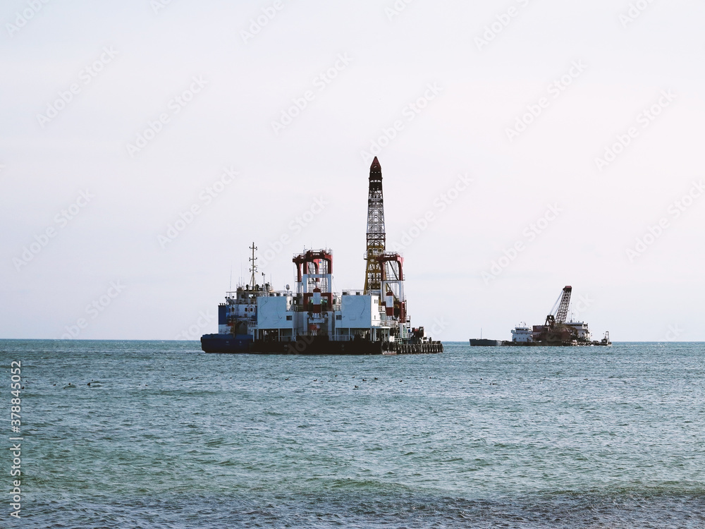 Dredger suction cutter when working on land reclamation, located on supports as anchors and ejected dredging soils. Dredger ships in operation