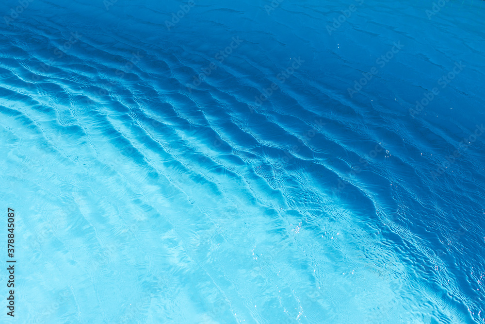 Obraz premium View of surface of turquoise water in swimming pool, sea or ocean, summer background. Gradient of color with waves. Concept rest, travel, wellness, spa procedures, season of vacations, sport