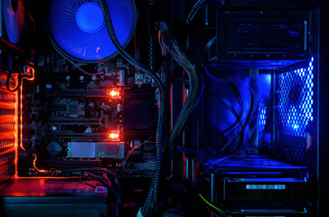 Computer with internal LED RGB lights and CPU cooling fans, hardware inside open high performance desktop PC, concept of repair and technology.