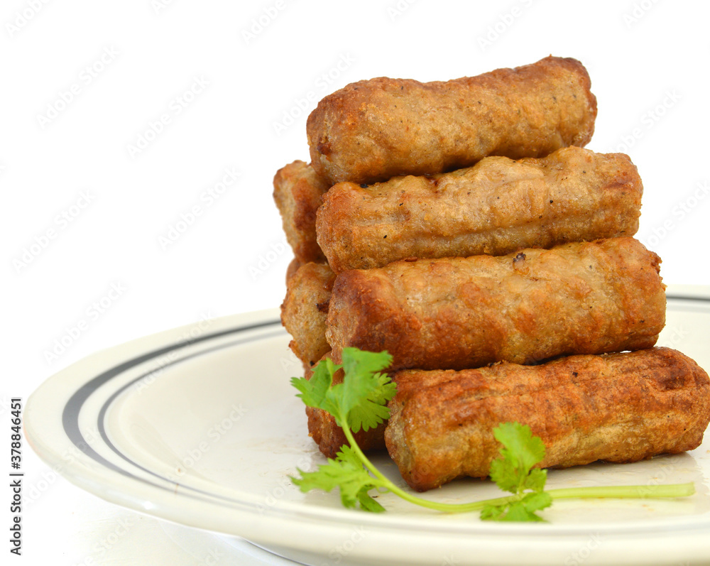 Cooked sausages arranged in plate on white