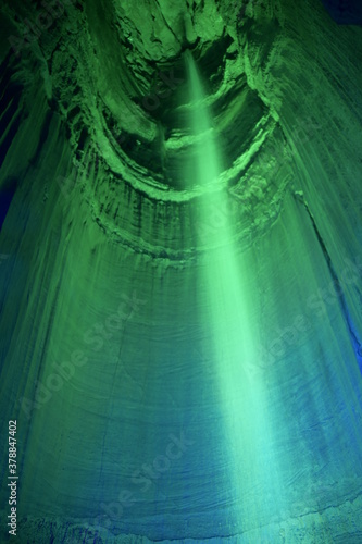 Photography Tall waterfall in a dark cavern with green lighting