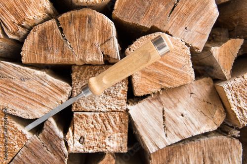 Formón de  carpintero para trabajar la madera  y de fondo troncos de madera para trabajar photo