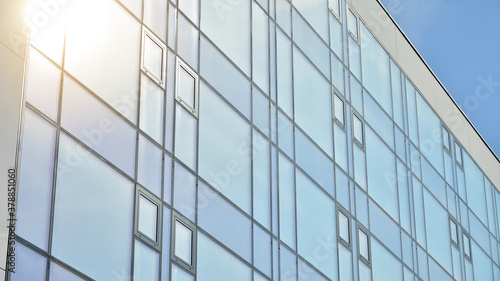 Office building, details of blue glass wall and sun reflections.